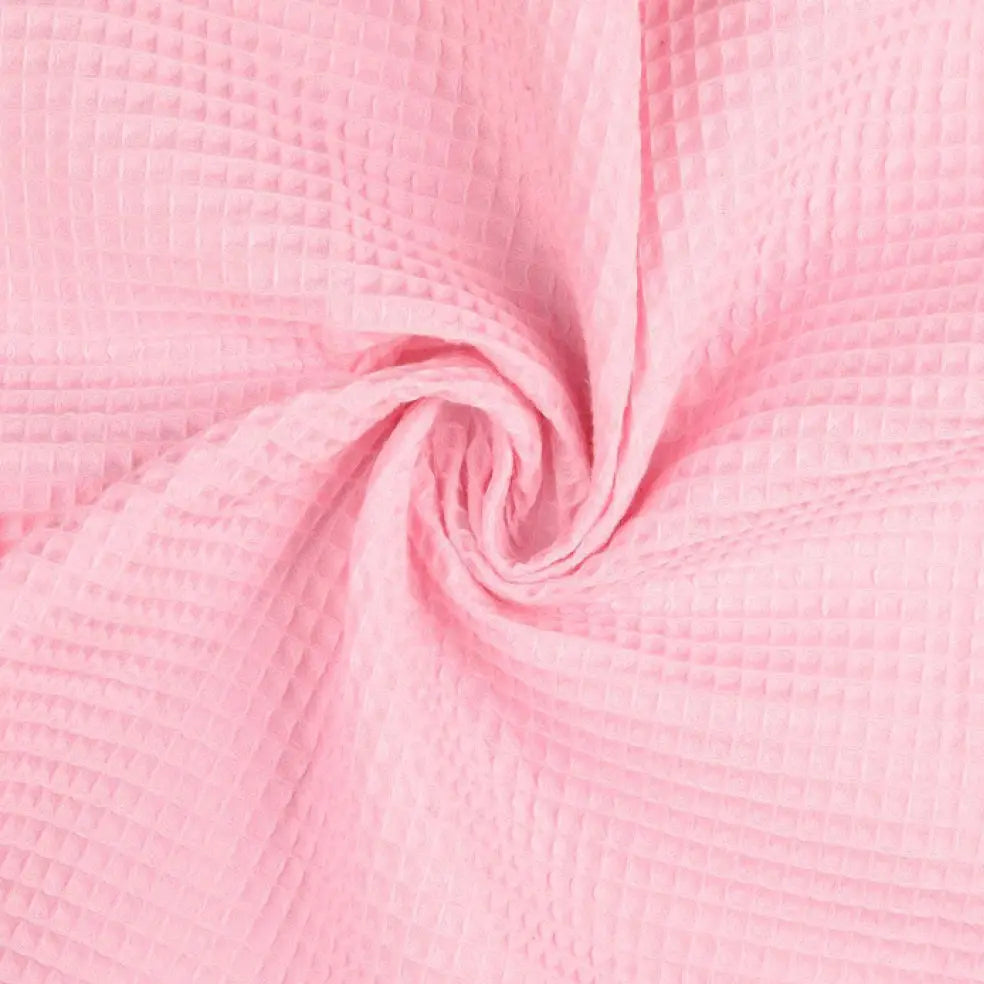 Baumwoll Waffelpiqué Stoff in Uni Rosa mit typischer Waffelstruktur, als Meterware gedreht dargestellt