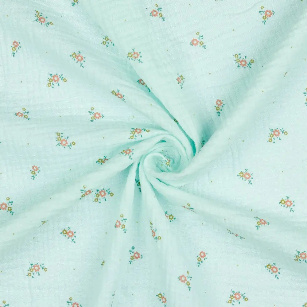 Musselin Double Gauze in Mint mit kleinen Streublümchen, weicher Baumwollstoff mit feinem Blümchenmuster, als Meterware gedreht dargestellt